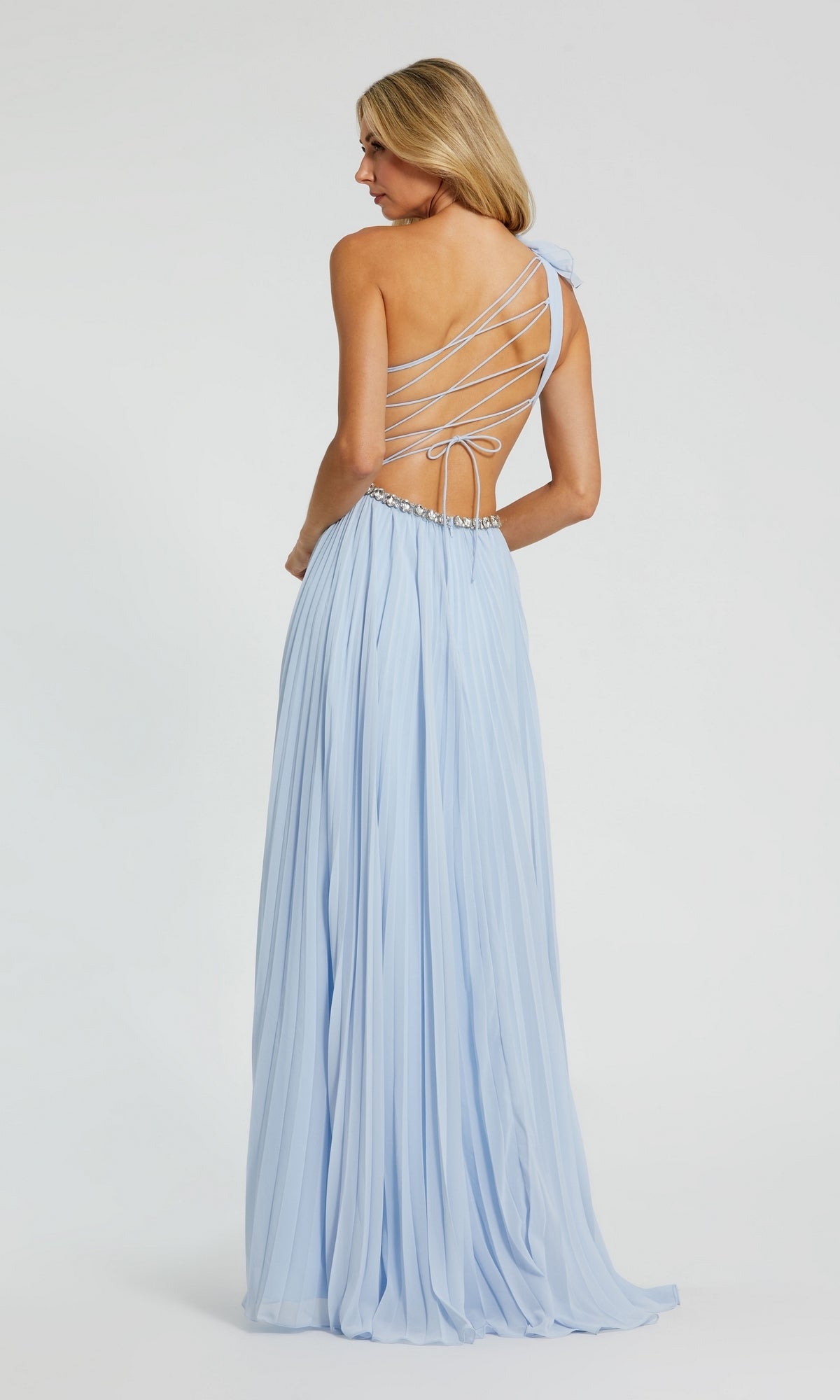 A woman wears the Long Formal Dress 49687 by Mac Duggal, featuring a powder blue one-shoulder A-line design with a pleated skirt and open crisscross back, standing against a plain white backdrop.